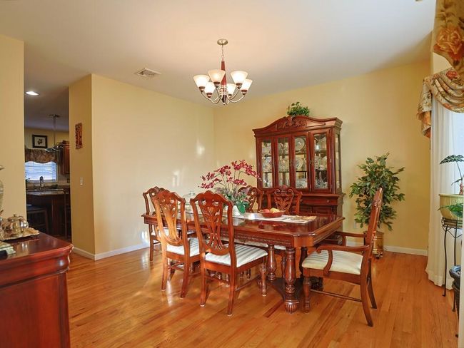 Dining space featuring baseboards, light wood-style floors, and a chandelier | Image 4
