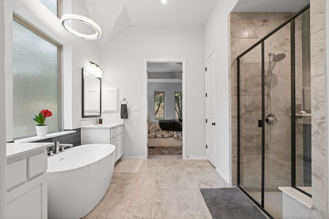 A marvelous light fixture and a large walk-in shower with a sitting area. | Image 20