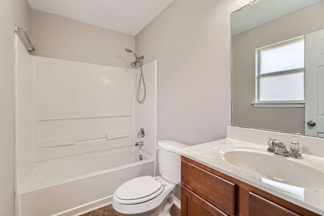 Bathroom featuring toilet, tub / shower combination, and vanity | Image 6