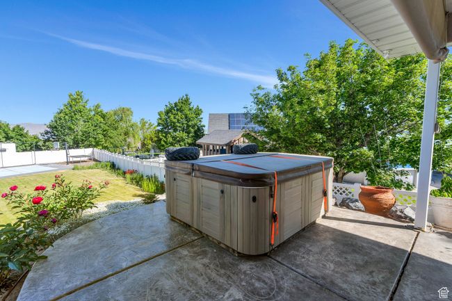 Fenced backyard featuring a hot tub, a patio, and a detached garage | Image 27