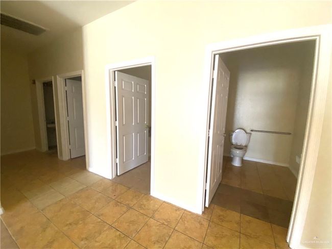 Unfurnished bedroom with light tile floors and connected bathroom | Image 15