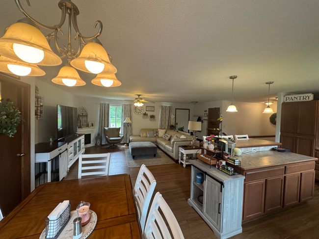 Dining room featuring dark wood finished floors, ceiling fan, and a textured ceiling | Image 5