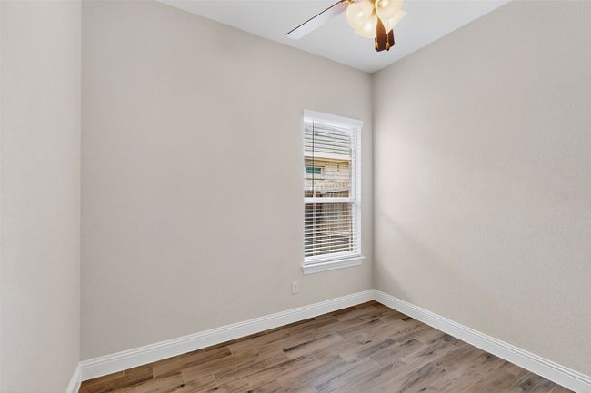 Empty room featuring a ceiling fan and wood finished floors | Image 23