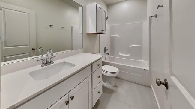 Full bath with bathing tub / shower combination, toilet, tile patterned flooring, and vanity | Image 16