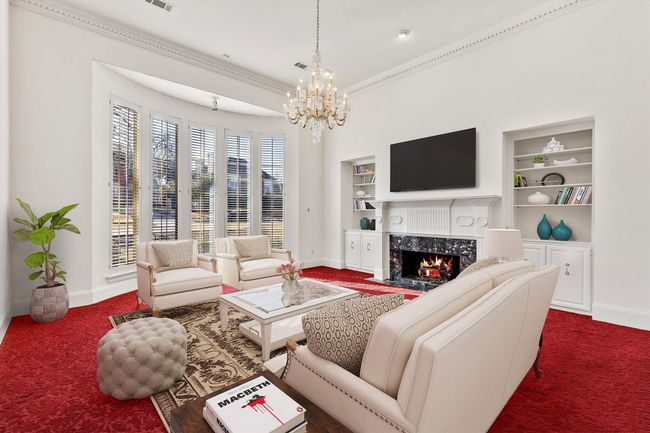Formal Living with a beautiful wall of windows with plantation shutters. Virtually Staged | Image 13