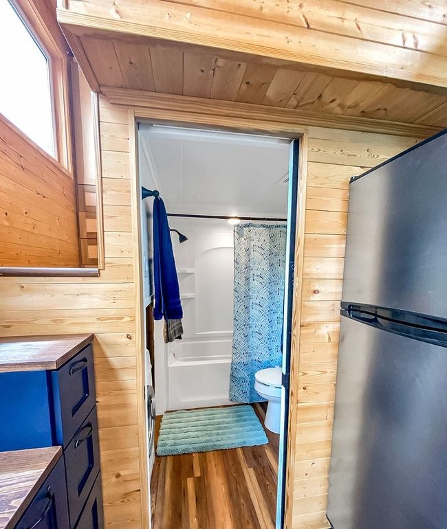 Bathroom featuring wood walls, wooden ceiling, wood finished floors, and shower / tub combo with curtain | Image 26