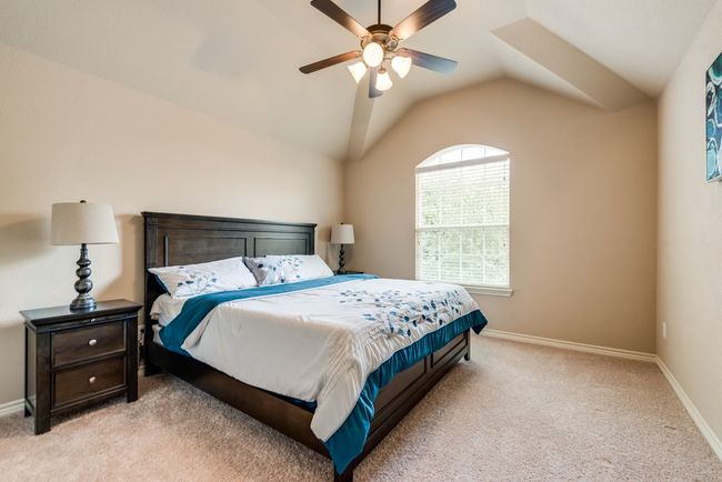 Bedroom featuring light carpet, lofted ceiling, baseboards, and a ceiling fan | Image 17