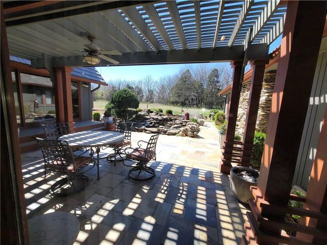 View of patio with a pergola, outdoor dining area, and a ceiling fan | Image 58
