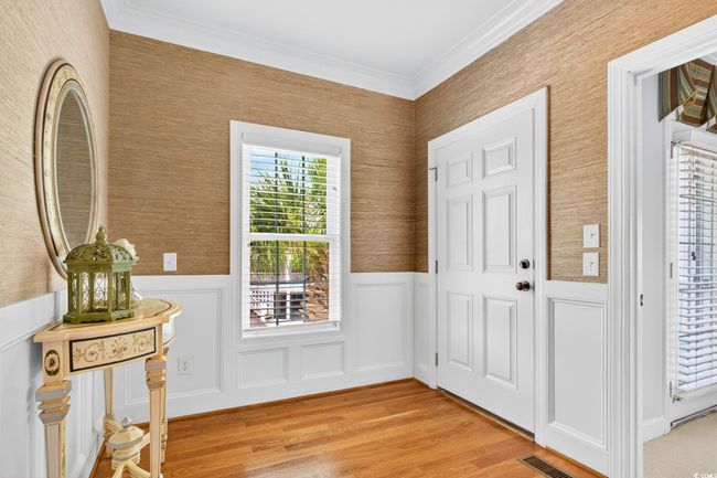 Foyer with light wood-style flooring, a wainscoted wall, and crown molding | Image 21