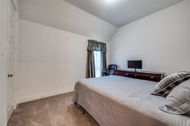 Bedroom with carpet floors, baseboards, and lofted ceiling | Image 19