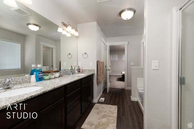 Bathroom featuring wood finished floors, double vanity, and baseboards | Image 18