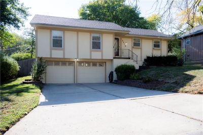 View of front of home with a front yard and a garage | Image 1