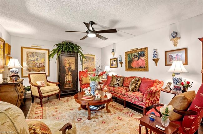 Living area with ceiling fan, wood finished floors, and a textured ceiling | Image 7