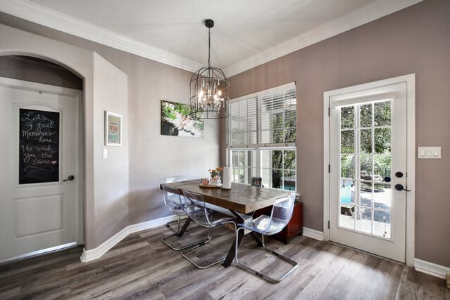 Dining area with wood finished floors, ornamental molding, and a chandelier | Image 9