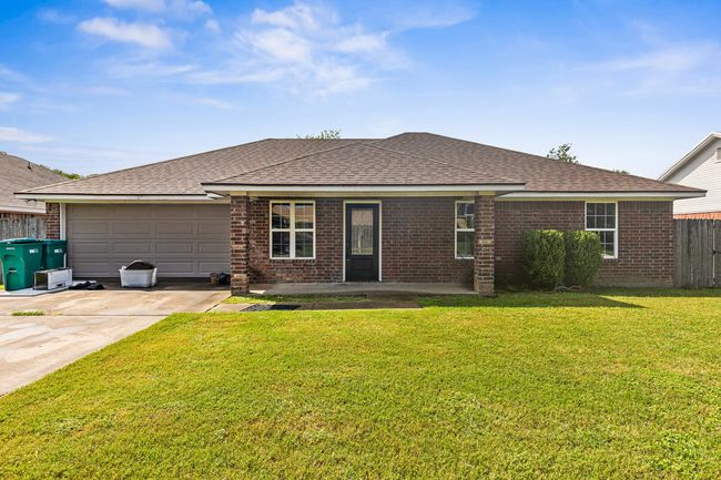 View of front facade featuring brick siding, concrete driveway, a garage, and a shingled roof | Image 4