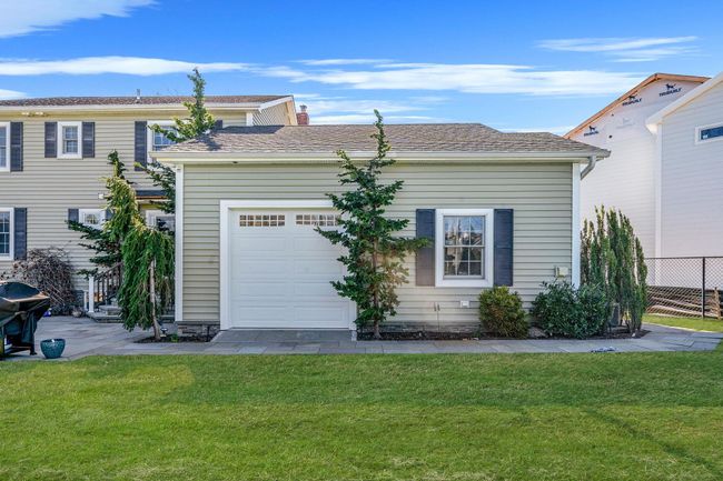 View of front of home featuring a front lawn, a chimney, fence, and a garage | Image 32