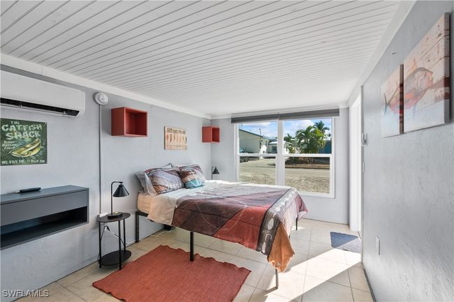 Bedroom featuring light tile patterned flooring and a wall mounted air conditioner | Image 18