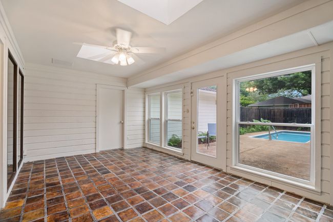 Unfurnished sunroom featuring skylights, tile floors, and a ceiling fan | Image 25