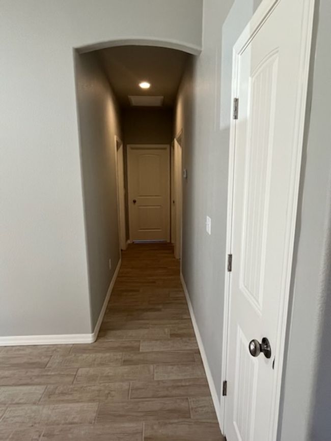 Corridor with light wood-style floors, arched walkways, baseboards, and recessed lighting | Image 14