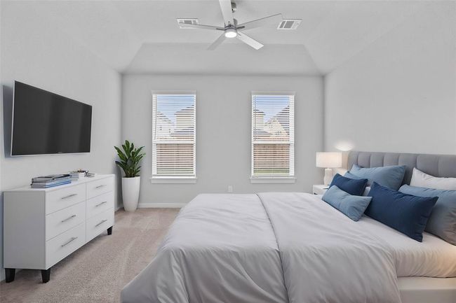 Come and unwind after a long day in this magnificent primary suite! This spacious room features plush carpet, neutral paint, high ceilings with ceiling fan, and large windows with privacy blinds. | Image 10