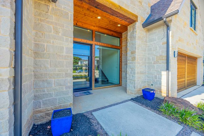 Property entrance featuring a shingled roof and stone siding | Image 33
