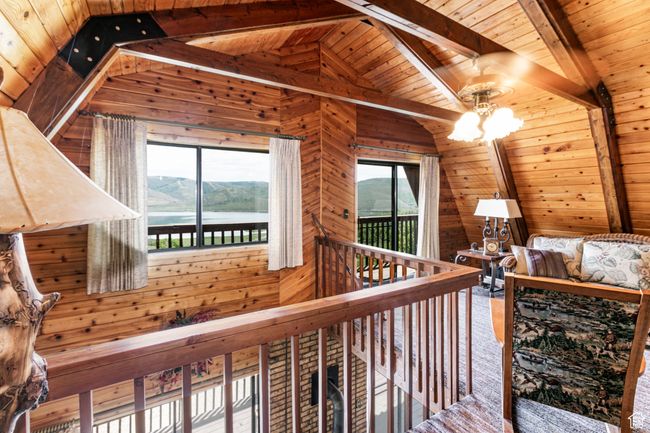 Hallway featuring wooden ceiling, wood walls, a chandelier, and a water view | Image 12