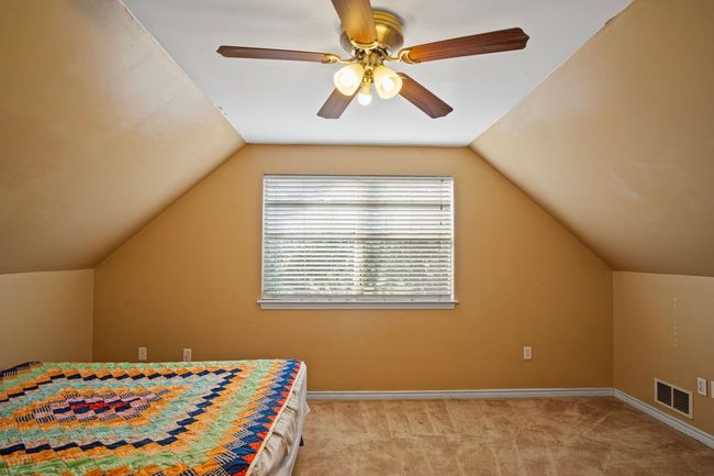 Bedroom featuring light colored carpet, lofted ceiling, and ceiling fan | Image 19