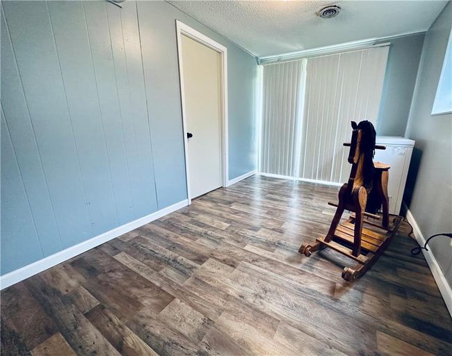 Workout area with wood finished floors, a textured ceiling, and baseboards | Image 22