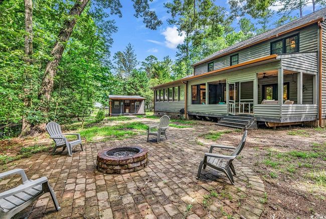 View of patio / terrace with a fire pit, a sunroom, and an outdoor structure | Image 37