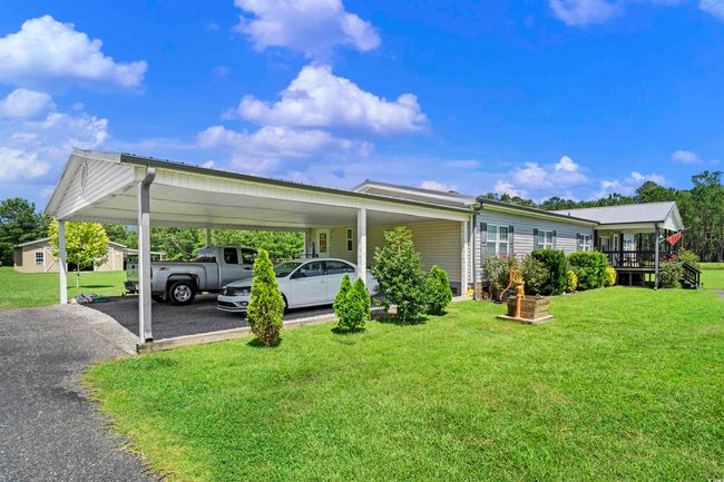 View of car parking featuring driveway and a carport | Image 27