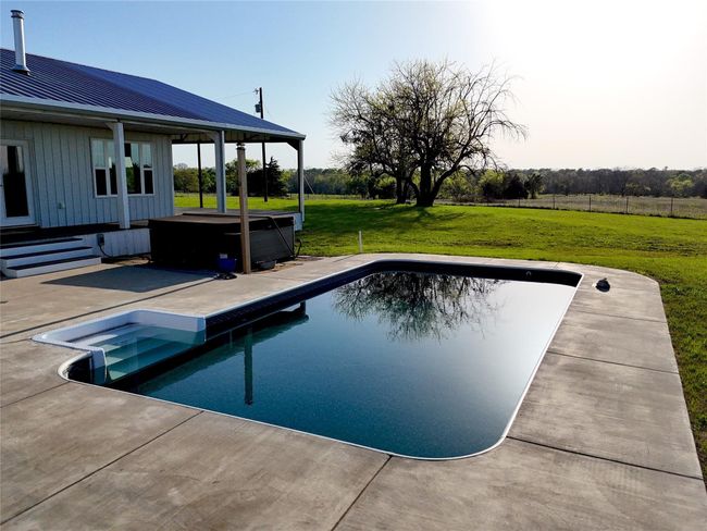Outdoor pool featuring a lawn and a patio area | Image 22
