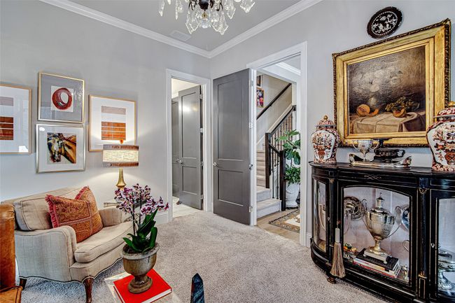 Living room featuring ornamental molding, a chandelier, stairs, visible vents, and carpet | Image 18