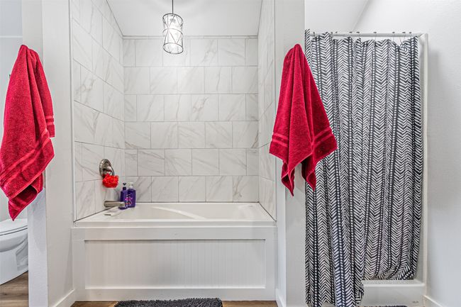 Bathroom with toilet and shower / bath combination with curtain | Image 23