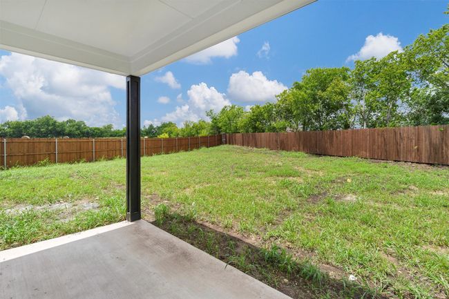 Fenced backyard with a patio area | Image 37