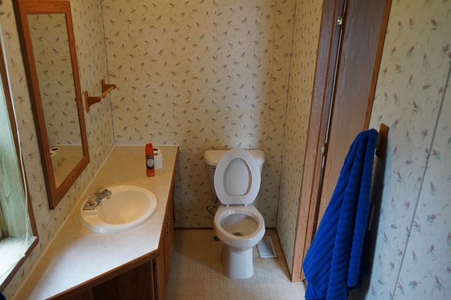 Bathroom with wallpapered walls, vanity, and tile patterned floors | Image 19
