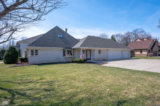 view of front facade featuring a front lawn, roof with shingles, concrete driveway, a garage, and brick siding | Image 35
