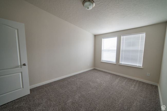 Empty room with baseboards, carpet, and a textured ceiling | Image 38