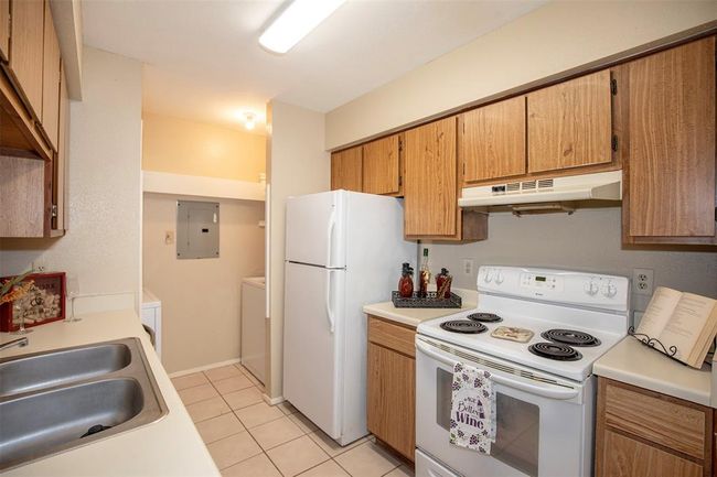 The well-appointed kitchen offers ample cabinet space and a convenient layout for effortless meal preparation. | Image 17