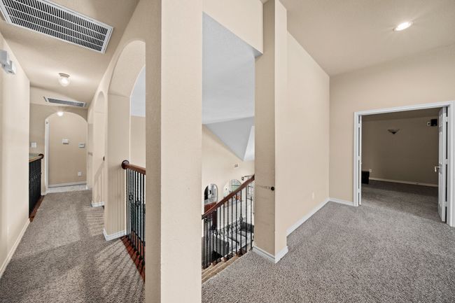 Corridor featuring carpet floors, an upstairs landing, arched walkways, and visible vents | Image 24