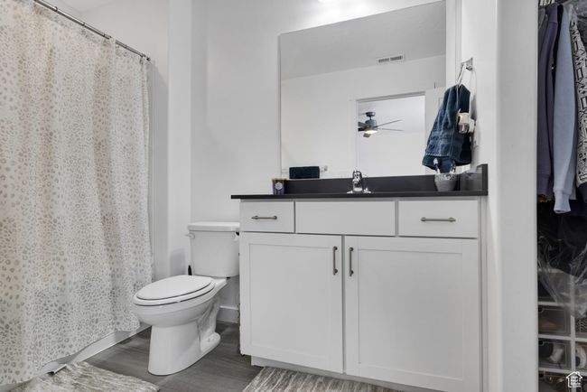 Full bathroom with wood finished floors, toilet, vanity, and ceiling fan | Image 15
