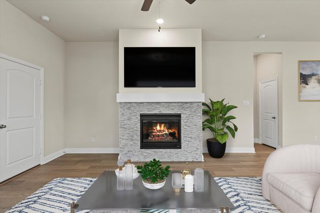 Living room featuring ceiling fan, wood finished floors, and a fireplace | Image 15