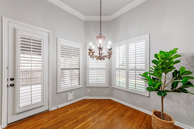 Unfurnished dining area featuring wood finished floors, a chandelier, crown molding, and baseboards | Image 17