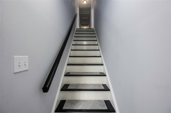 Corridor with an inviting chandelier, lofted ceiling, and dark carpet | Image 30