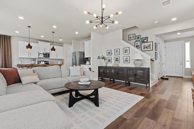 Living room featuring recessed lighting, wood finished floors, and a chandelier | Image 4