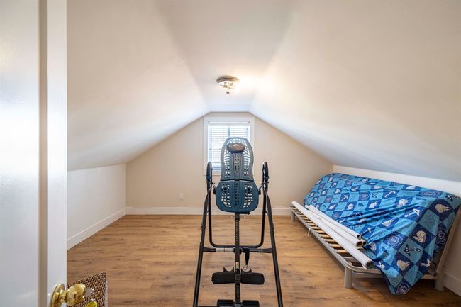 Bedroom featuring vaulted ceiling, wood finished floors, and baseboards | Image 20