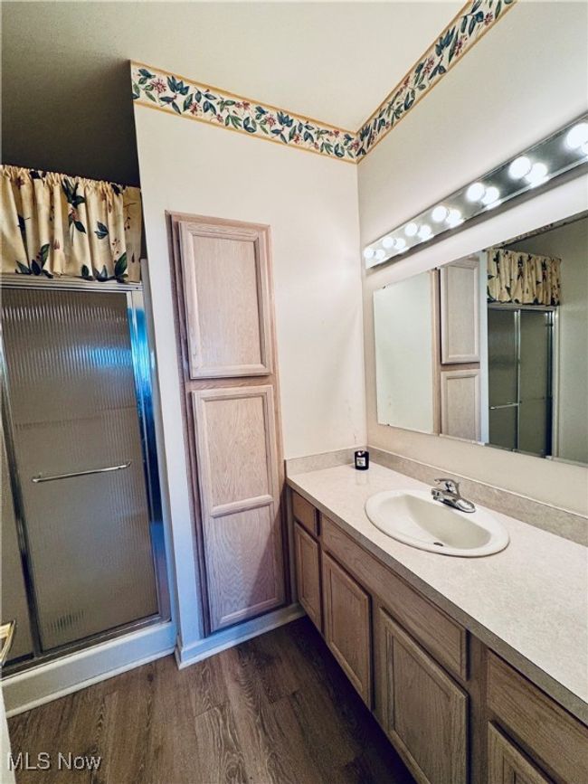 Bathroom with wood finished floors, vanity, and a shower with door | Image 24