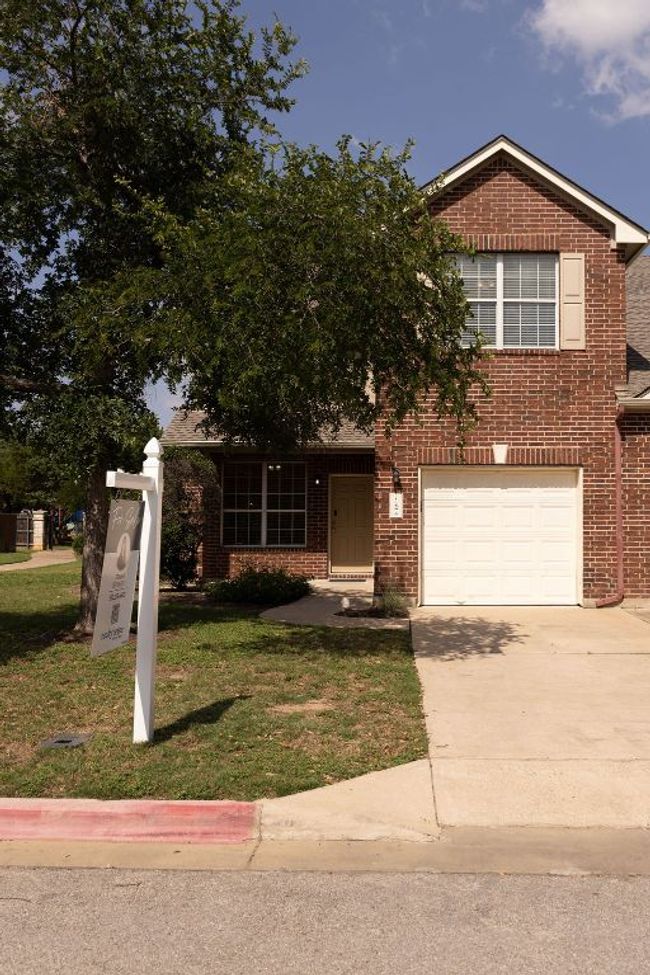 View of front of house featuring brick siding, concrete driveway, a front yard, and a garage | Image 31