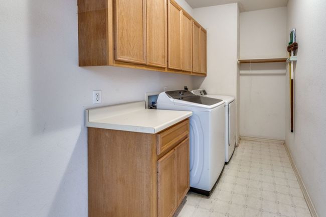 Laundry area with washing machine and dryer, baseboards, cabinet space, and light floors | Image 31
