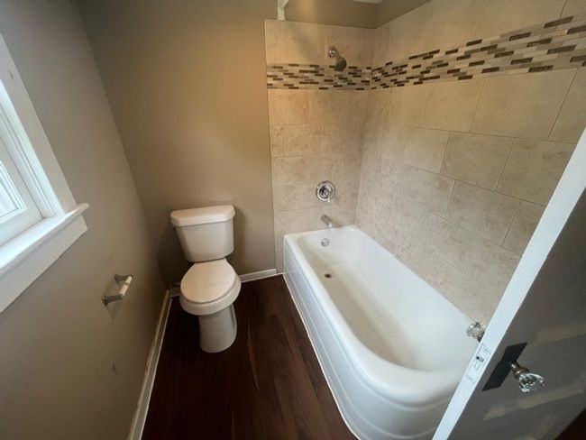 Full bathroom featuring wood finished floors and bathing tub / shower combination | Image 32