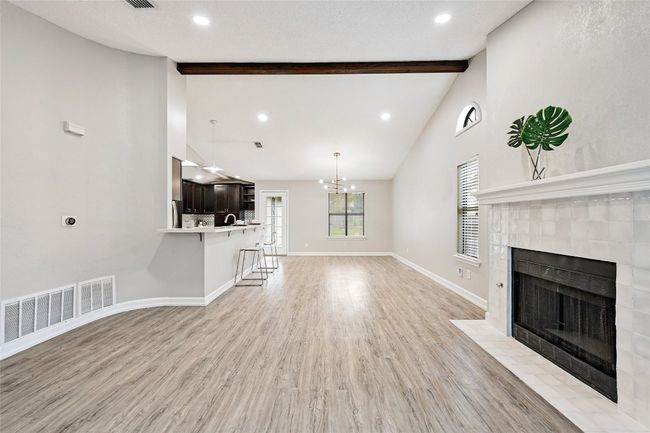 This great room has a beautiful vaulted ceiling with original beam and is an open concept with a large flowing living/dining room. | Image 4